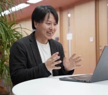 パソコンに向かって話す男性従業員